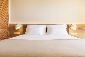 阿尔图拉阿尔图拉优若托尔酒店的一间卧室配有带白色床单和枕头的床。