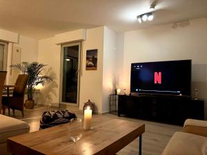 科隆Stylish, cosy flat close to Cologne City Center的客厅配有电视和木桌。