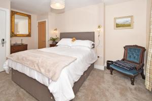 莱姆河下游的纽卡尔斯The Masons Arms的一间卧室配有一张大床和一张蓝色椅子