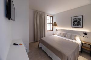 休达德亚Tres Tocs的白色的卧室设有床和窗户