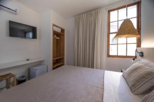 休达德亚Tres Tocs的卧室设有一张白色大床和一扇窗户。