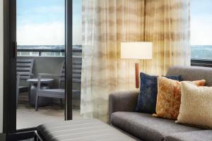 西棕榈滩西棕榈滩中心希尔顿合博套房酒店的带沙发、椅子和窗户的客厅