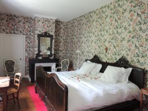 丰特夫罗拉拜Le Domaine de Mestré, The Originals Relais (Relais du Silence)的一间卧室配有一张带花卉壁纸的大床