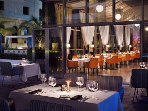 迪拜朱美拉海滩瑞享酒店的餐厅设有白色的桌椅和窗户。
