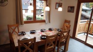 莫尔济讷Chalet Rivendell, Morzine sleeps 10 with garage的餐桌,配有椅子和玻璃杯