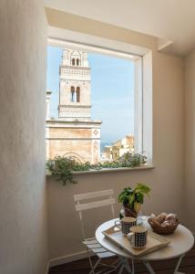 加埃塔Altavilla的一间设有桌子和窗户的客房,窗户上设有钟楼