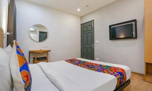 新德里FabHotel Urban Residency的一间卧室配有一张床和一台平面电视