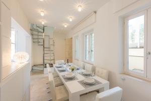 罗马Amazing 3 Levels Penthouse Piazza Venezia的白色的用餐室配有白色的桌椅