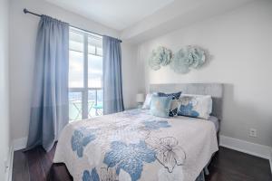 多伦多GLOBALSTAY Modern Downtown Apartment的一间卧室配有一张带蓝色和白色床单的床。