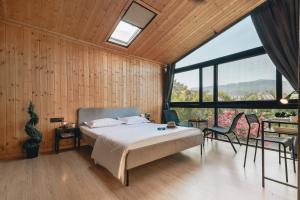 罗纳瓦拉Kabins - Homestay Near Pawna Lake, Lonavala的一间卧室设有一张床和一个大窗户