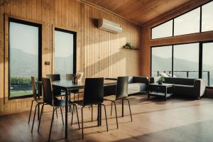 罗纳瓦拉Kabins - Homestay Near Pawna Lake, Lonavala的一间带桌椅和沙发的用餐室