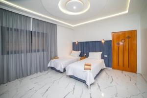 艾兹鲁RIAD GOLD的酒店客房设有两张床和大窗户。