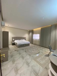 欧拉مشار العلا للشقق الفندقيه 1的一间卧室设有一张床,铺有大型大理石地板。