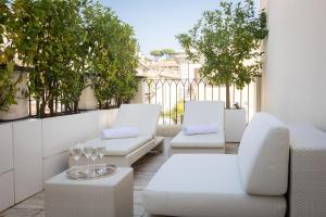 罗马Amazing 3 Levels Penthouse Piazza Venezia的阳台的庭院配有白色的桌椅