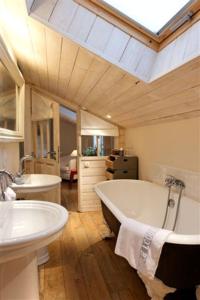 滨海拉特里尼泰戈斯贝小屋酒店的大型浴室设有两个盥洗盆和浴缸。