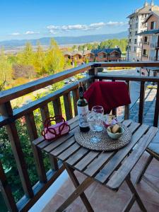 拉兹洛格Kate's apartment in Pirin的阳台上的野餐桌,提供一瓶葡萄酒