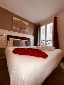 巴黎拉法叶特庭院剧场酒店的一张白色的大床,上面有红色的连衣裙
