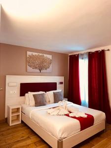 巴黎拉法叶特庭院剧场酒店的一间卧室配有一张带红色窗帘的大床