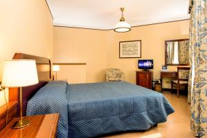 雷焦艾米利亚艾尔伯格瑞吉欧酒店的一间卧室配有蓝色的床和一张书桌