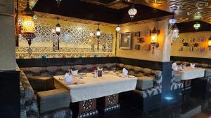 班加罗尔Sterlings Mac Hotel的一间设有两张桌子和瓷砖墙的餐厅