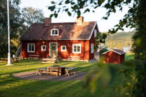 VallstaSTF Undersvik Gårdshotell & Vandrarhem的一间红色的房子,前面设有野餐桌