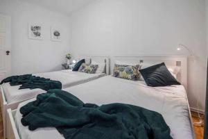 奥迪韦拉什Apart Lisboa confortavel 2 quartos com terraço的卧室内的两张床和绿毯