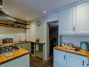 布里奇诺斯Beautiful 2 Bedroom Riverside Cottage的厨房配有白色橱柜和炉灶烤箱。