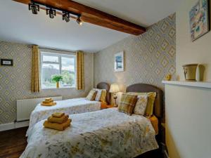 布里奇诺斯Beautiful 2 Bedroom Riverside Cottage的一间卧室设有两张床和窗户。