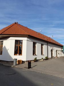 BítovanyPenzion a restaurace U Nováků的街道上白色的建筑,有红色的屋顶
