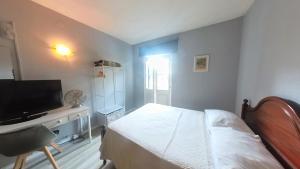 丰沙尔Funchal 19的一间卧室配有一张床和一张书桌及电视