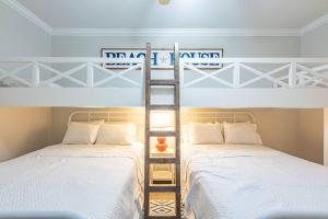 奥兰治比奇The Bluebird OBA at Phoenix West II的带两张双层床的客房中的两张床