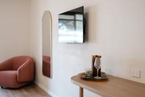 巴瑟尔顿The Timothée Resort的配有桌子、椅子和镜子的房间