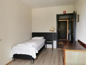 曼达尔SKAP Hostel Mandal的一间卧室配有一张床和一张书桌