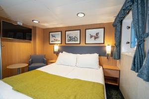 特罗姆瑟Quest的一间卧室,卧室配有一张床和一张船上的椅子