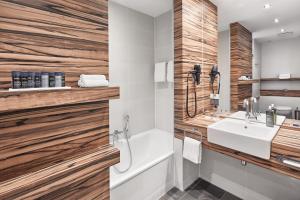 明斯特H4明斯特酒店的一间带白色水槽和木墙的浴室