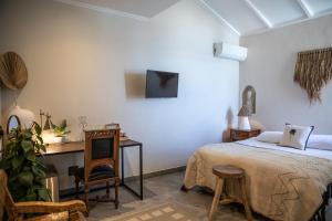 开普敦普利米大海城堡酒店的一间卧室配有一张床、一张书桌和一台电视。