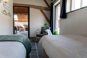 RielBoerensuite, heerlijk verblijf in het Karschop的一间卧室设有一张床和一间客厅。