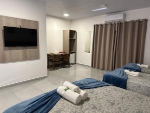 沙帕达-杜斯吉马朗伊斯POUSADA ACONCHEGO MT的酒店客房设有两张床和一台平面电视。