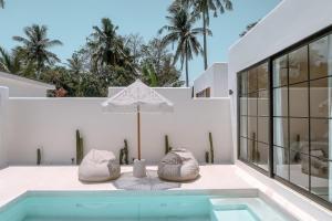 吉利特拉旺安Cahaya Villas - Luxury Villa With Private Pool的一座房子里一个带两把椅子和一把遮阳伞的游泳池