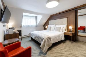 布拉格Hotel Ikona的酒店客房带一张床、一张桌子和椅子