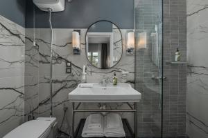 塞萨洛尼基No 39 Svolou Suites的一间带水槽和镜子的浴室