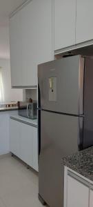 卡皮托利乌Apartamento Aconchegante的厨房配有不锈钢冰箱和白色橱柜