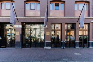 阿姆斯特丹Hotel van de Vijsel的玻璃门和旗帜的建筑物外墙
