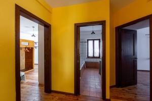 CasseroRelais Castel d'Emilio – Casa ARANCIO的黄色墙的房间里有两个门