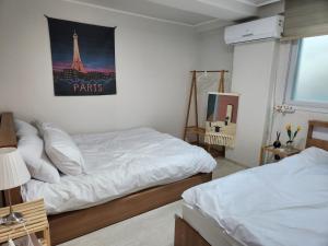 首尔The Shim Anam 3rooms late check in-out的一间卧室设有两张床,享有艾菲尔铁塔的景色。