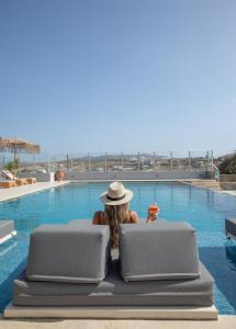 克洛瓦斯亚历山德罗米科诺斯酒店的坐在游泳池前戴帽子的女人