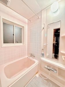 白马村Moment Chalet Hakuba的白色的浴室设有浴缸和窗户。