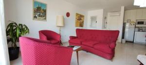别德马Departamento ubicado en Viedma Centro. Amplio, comodo y confortable.的客厅配有两张红色的沙发和一张桌子