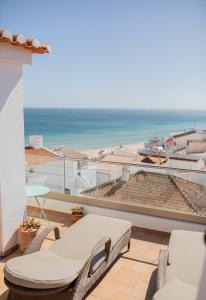 塞勒玛Casa Pedro in Salema - Oceanview & beach的一个带椅子的阳台,享有海滩美景