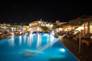 克洛瓦斯亚历山德罗米科诺斯酒店的一座夜间游泳池,其建筑背景为: